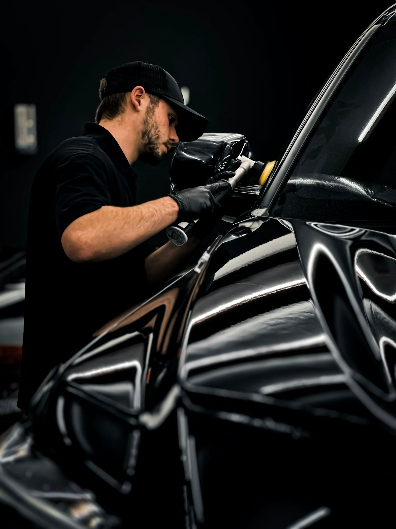 Hand-applied wax protection on a dark car